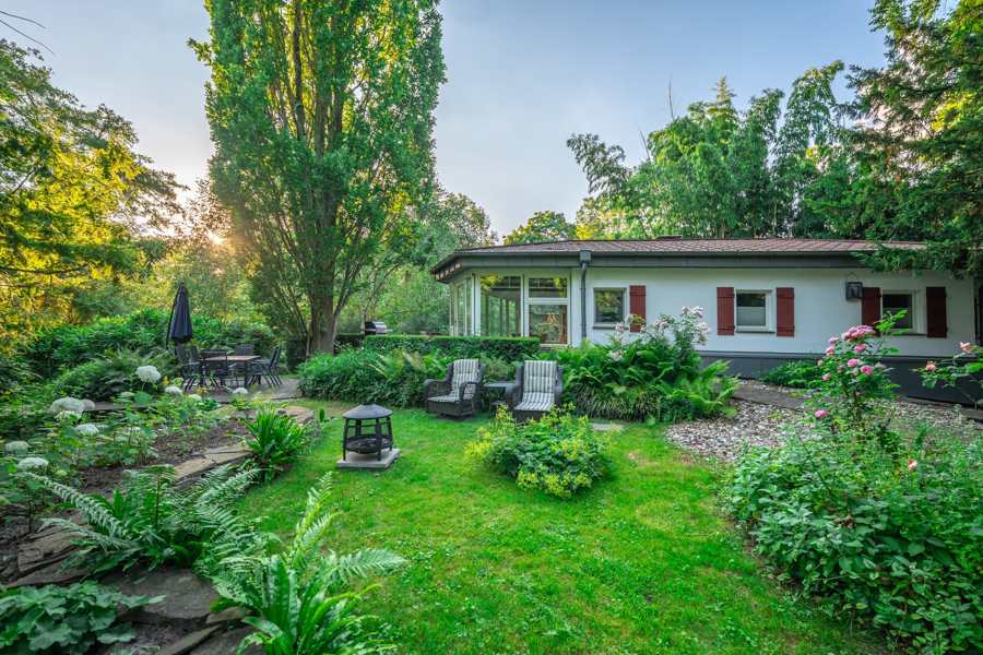 Das Wersehaus mit Wintergarten, Feuerschale und Sitzecken im grünen Garten