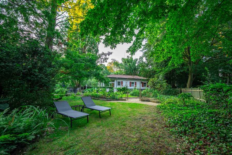 Zwei Sonnenliegen auf der Wiese mit dem Haus im Hintergrund