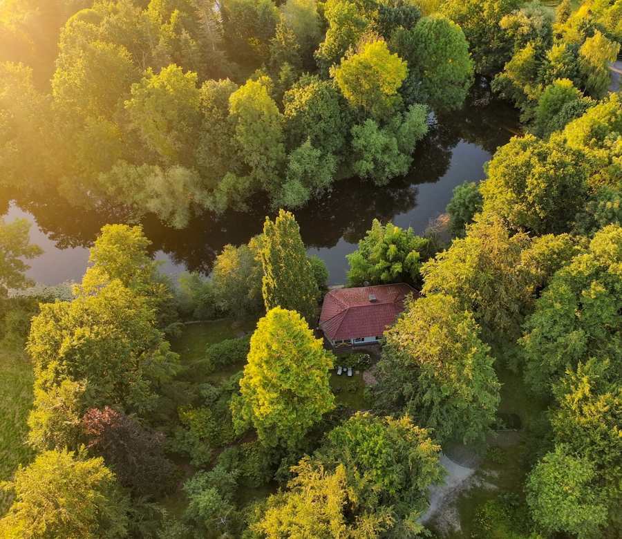 Luftaufnahme im Abendlicht: das Wersehaus versteckt im Grünen an der Werse